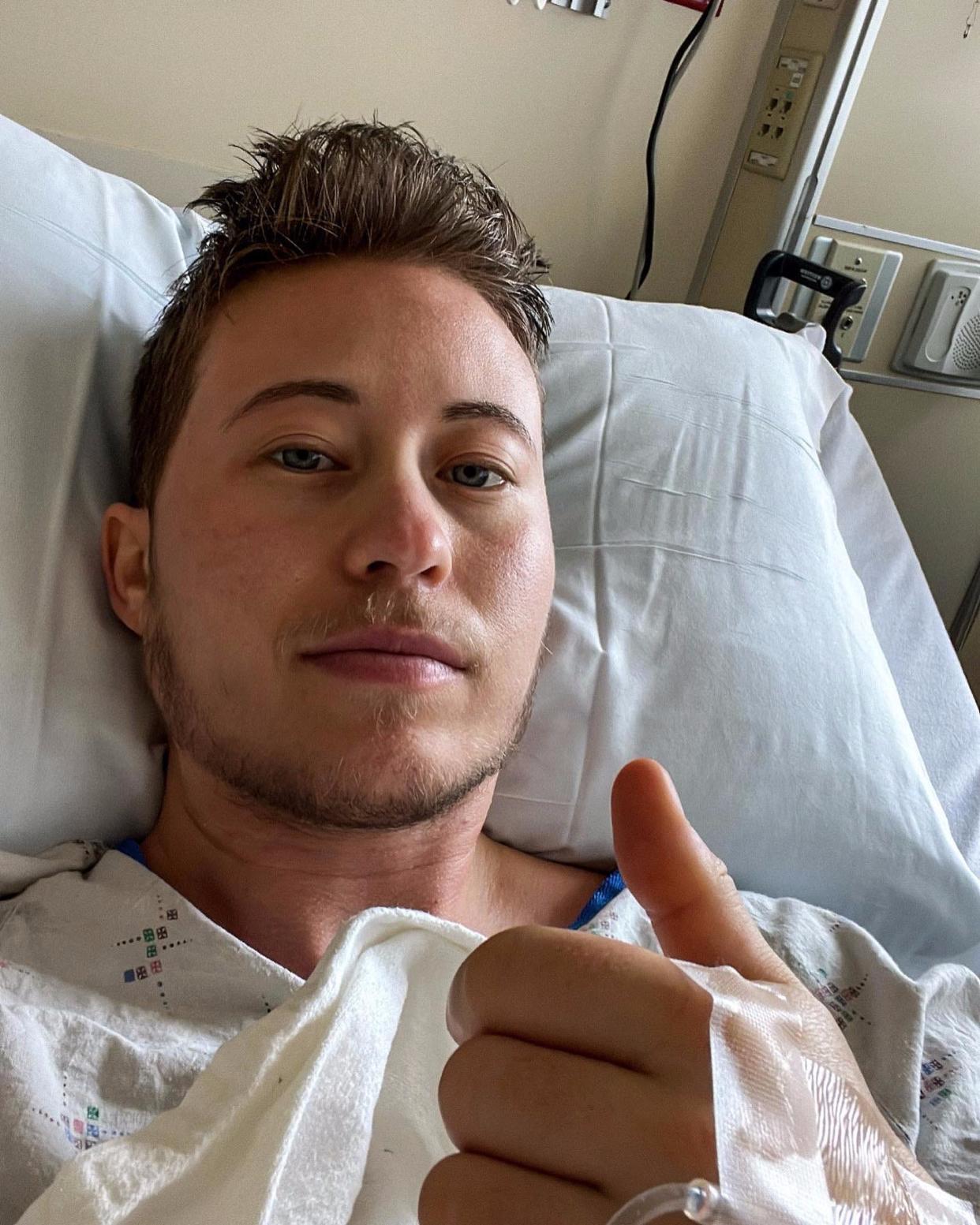 Influencer Luke Pearson from the neck up giving a thumb's up in a hospital bed