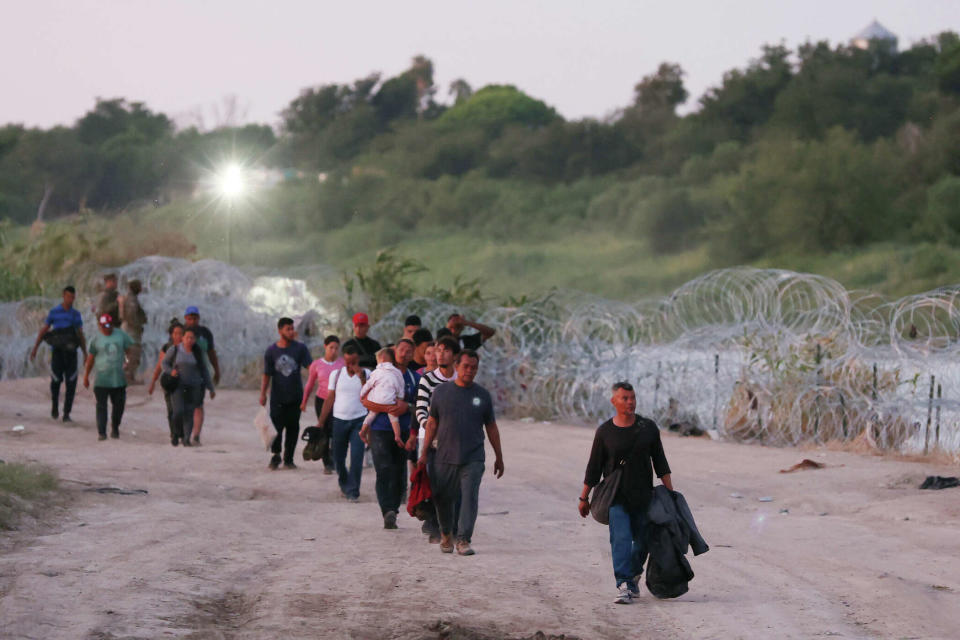 Migrants walk to a U.S. Border Patrol processing area in Eagle Pass, Texas, last month. Over the summer, state officials directed hundreds of migrants onto properties where they were promptly arrested.