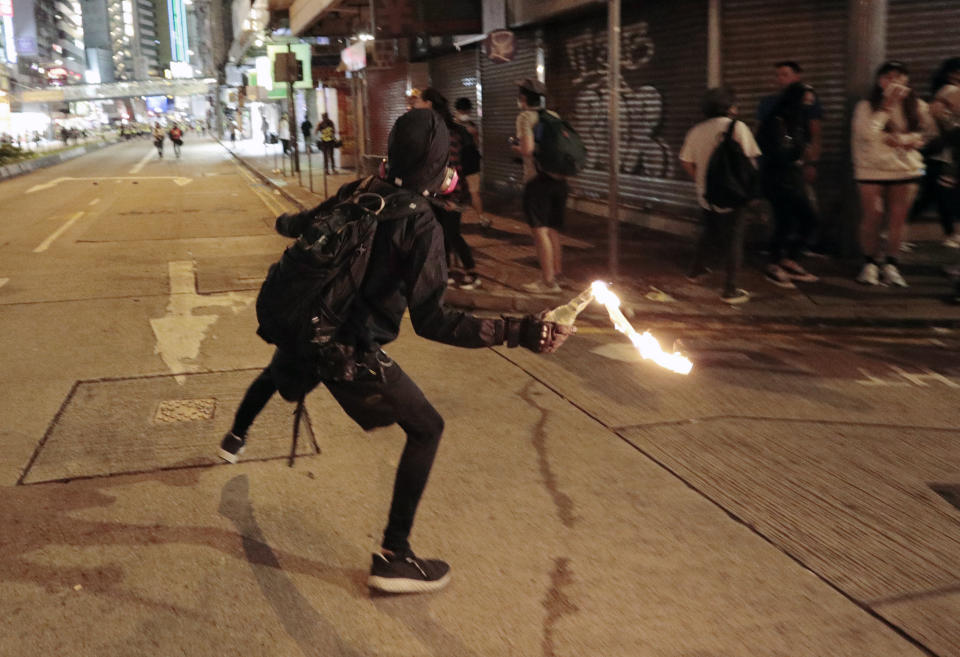 A protester prepares to hurl a molotov cocktail toward police during clashes in Hong Kong, Saturday, Nov. 2, 2019. Riot police fired multiple rounds of tear gas and used water cannons Saturday to swiftly break up a rally in downtown Hong Kong by thousands of masked protesters demanding meaningful autonomy after Beijing indicated it could tighten its grip on the Chinese territory. (AP Photo/Dita Alangkara)