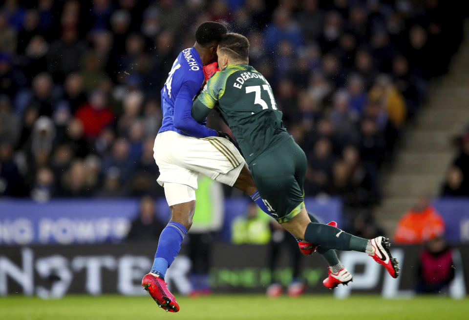 Leicester City's Kelechi Iheanacho, left, clashes with Manchester City goalkeeper Ederson, as he has a shot on goal blocked, during their English Premier League soccer match at the King Power Stadium in Leicester, England, Saturday Feb. 22, 2020. (Nick Potts/PA via AP)