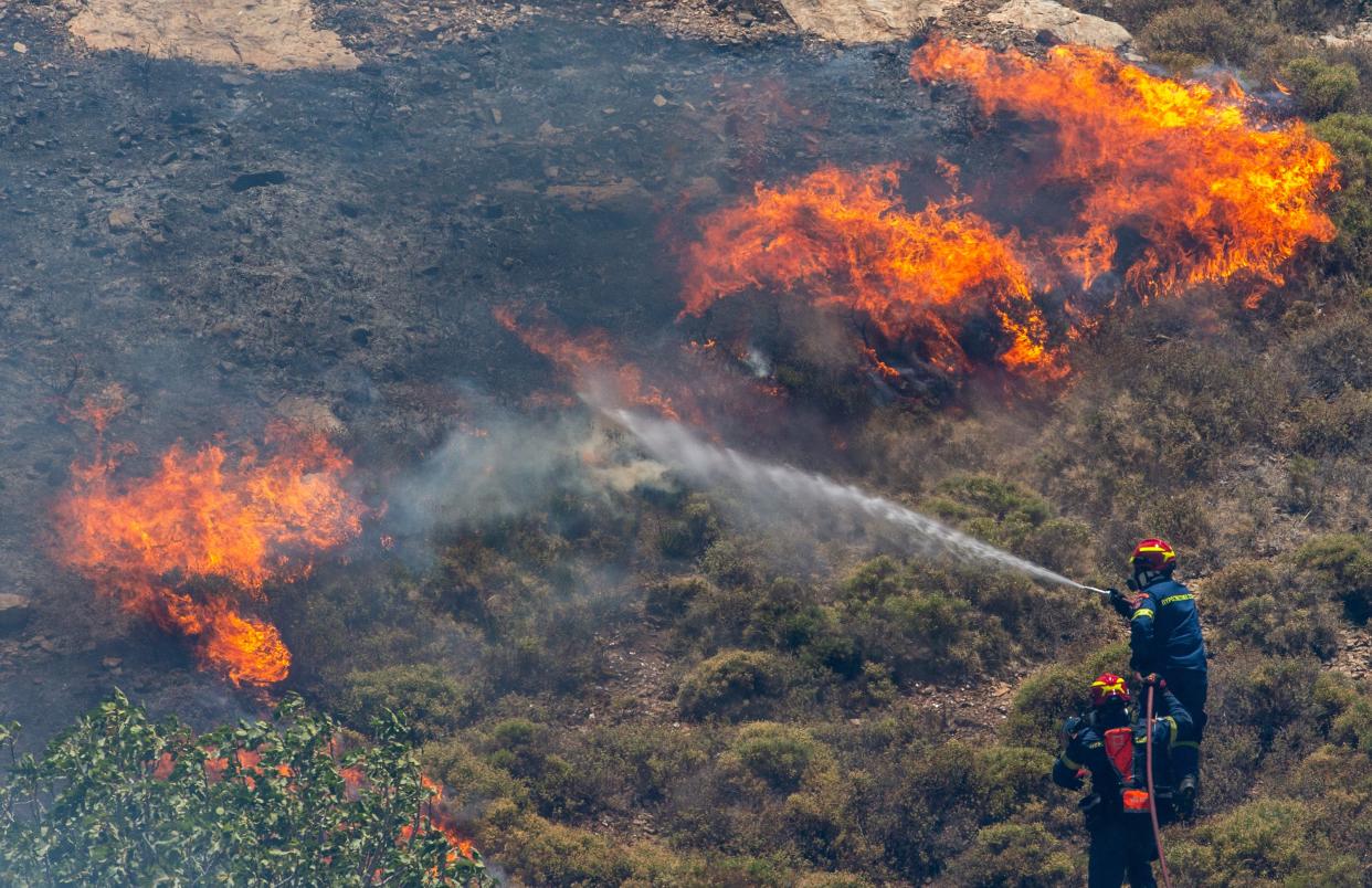 Firefighters try to put out wildfires in the forest at Keratea, southeast of Athens, Greece, June 30, 2024.  Since the start of the wildfire season on May 1, firefighters are called to handle dozens of wildfires every day across the country. (Photo by Marios Lolos/Xinhua via Getty Images)