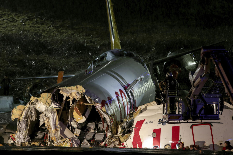 CAPTION CORRECTS NUMBERS INJURED - Rescue members and firefighters work after a plane skidded off the runway at Istanbul's Sabiha Gokcen Airport, Istanbul, Wednesday, Feb. 5, 2020. A plane skidded off the runway Wednesday at Istanbul’s Sabiha Gokcen Airport, crashing into a field and breaking into pieces. Passengers were seen evacuating through cracks in the plane and authorities said dozens have been injured. (Can Erok/DHA via AP)