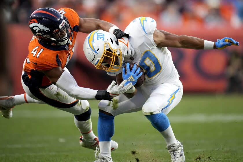 Denver Broncos inside linebacker Kenny Young (41) tackles Los Angeles Chargers running back Austin Ekeler during the second half of an NFL football game, Sunday, Nov. 28, 2021, in Denver. (AP Photo/David Zalubowski)