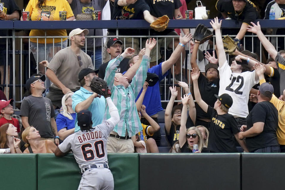 Detroit Tigers left fielder Akil Baddoo watches as fans reach to pull in a home run ball hit by Pittsburgh Pirates' Liover Peguero in the second inning of a baseball game in Pittsburgh, Tuesday, Aug. 1, 2023. (AP Photo/Matt Freed)