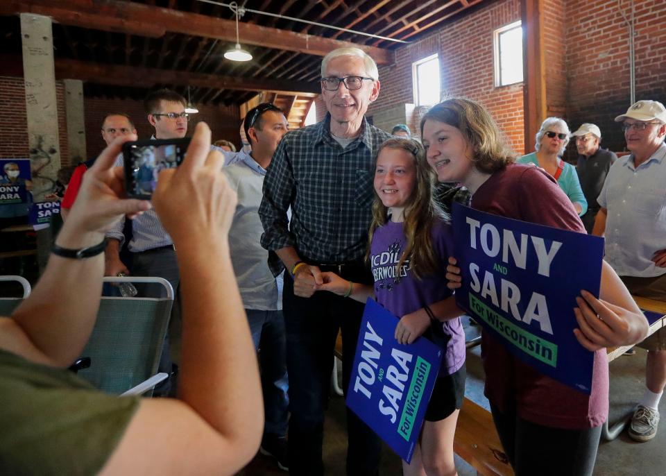 Gov. Tony Evers poses for a photo with supporters during a campaign stop in Stevens Point.