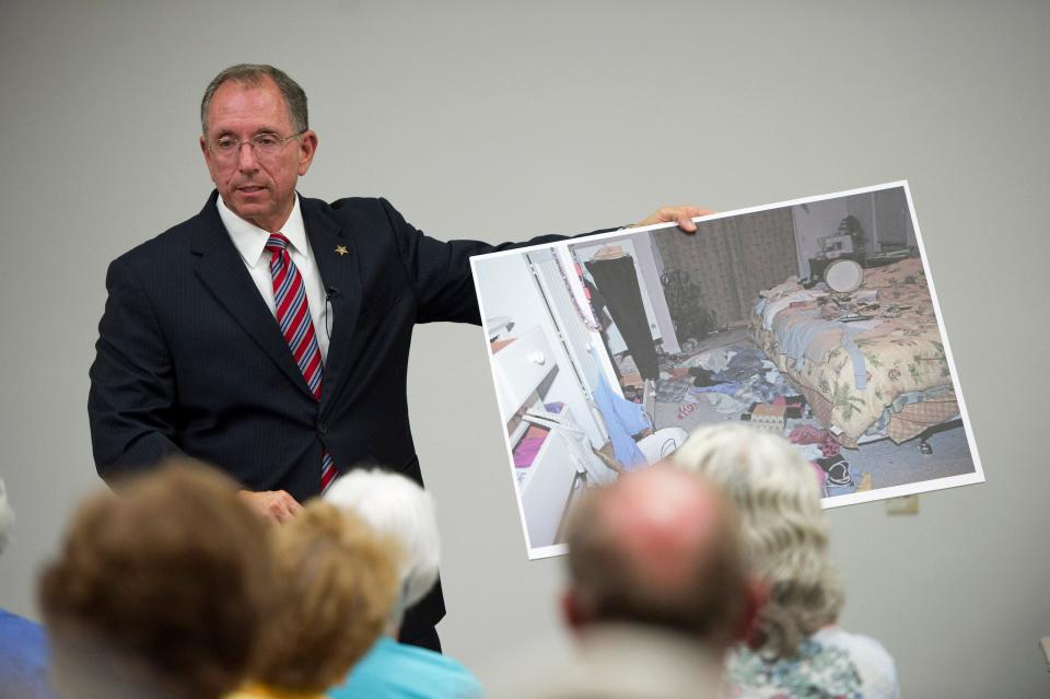 Martin County Sheriff William D. Snyder holds up a crime scene photo from one of the pillowcase burglaries as he discusses how the burglars operate during the first of four town hall meetings to discuss the pillowcase burglaries, at the Robert Morgade Library in Stuart April 9, 2013.