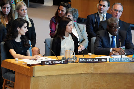 Amal Clooney and Nadia Murad listen to Denis Mukwege speaking at the United Nations Security Council during a meeting about sexual violence in conflict in New York, New York, U.S., April 23, 2019. REUTERS/Carlo Allegri