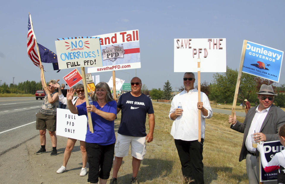 Supporters of a fully funded oil check known as a Permanent Fund Dividend or PFD, hold signs Monday, July 8, 2019, in Wasilla, Alaska. Some Alaska lawmakers are meeting in Wasilla July 8 instead of Juneau, where state House and Senate leadership have decided to hold the special session. (AP Photo/Mark Thiessen)