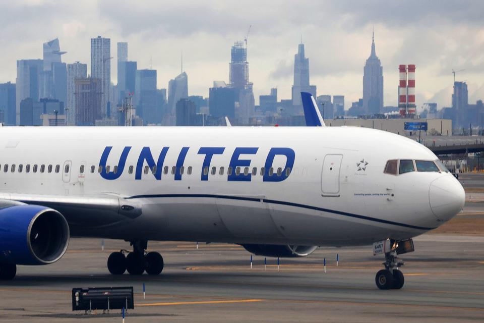 <p>Gary Hershorn/Getty</p> A United Airlines plane sits at the gate at Newark Liberty International Airport 