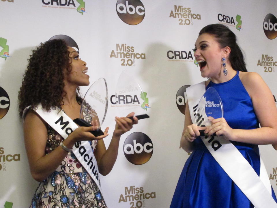 Miss Massachusetts Gabriela Taveras, left, and Miss Indiana Lydia Tremaine celebrate after winning preliminary competition awards in the Miss America pageant Friday Sept. 7, 2018 in Atlantic City, N.J. Taveras won the onstage interview and Tremaine won the talent portion. (AP Photo/Wayne Parry)