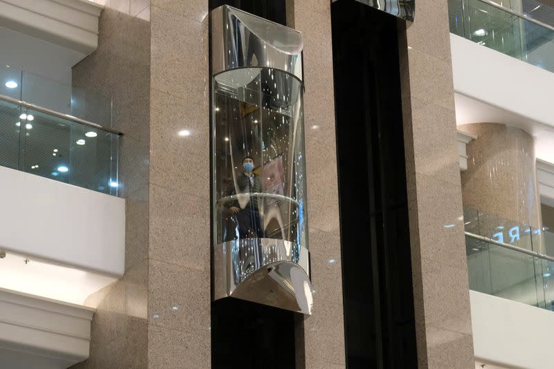 A man wearing protective mask rides a lift inside at Times Square shopping centre, following the outbreak of the new coronavirus, in Hong Kong