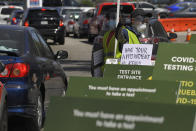 Workers direct cars as they wait in line for coronavirus testing at Dodger Stadium Tuesday, July 14, 2020, in Los Angeles. (AP Photo/Mark J. Terrill)