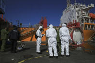 CORRECTS DAY TO TUESDAY - Experts investigate a tank at the site of a toxic gas explosion in Jordan's Red Sea port of Aqaba, Tuesday, June 28, 2022. A crane loading chlorine tanks onto a ship on Monday dropped one of them, causing an explosion of toxic yellow smoke that killed over a dozen people and sickened some 250, authorities said. (AP Photo/Raad Adayleh)