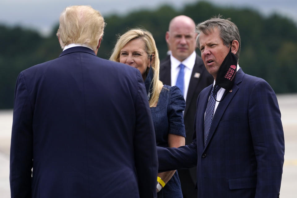 FILE - President Donald Trump greets Georgia Gov. Brian Kemp and his wife Marty as he arrives at Dobbins Air Reserve Base for a campaign event at the Cobb Galleria Centre, Sept. 25, 2020, in Atlanta. (AP Photo/Evan Vucci, File)