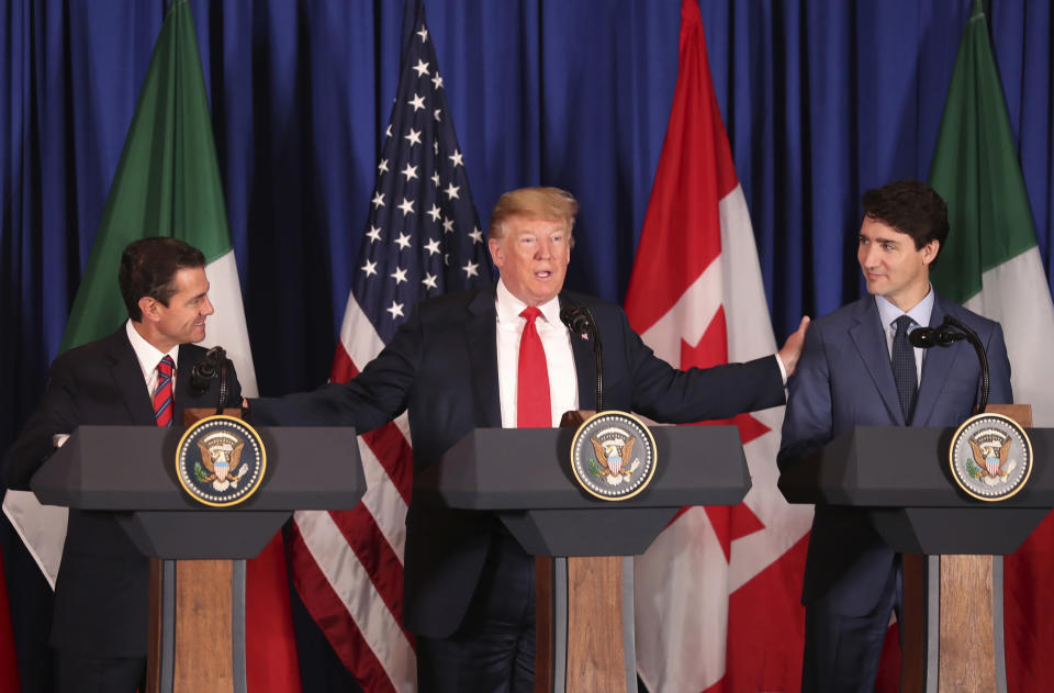 President Donald Trump, center, reaches out to Mexico's President Enrique Pena Nieto, left, and Canada's Prime Minister Justin Trudeau as they prepare to sign a new United States-Mexico-Canada Agreement that is replacing the NAFTA trade deal, during a ceremony at a hotel before the start of the G20 summit in Buenos Aires, Argentina, Friday, Nov. 30, 2018. (AP Photo/Martin Mejia)