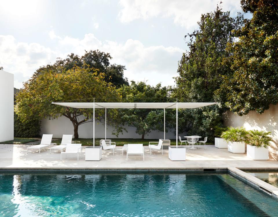 The same white limestone in the pool area is used for the first floor of the house. The outdoor furniture is a mix of Blu Dot and vintage Bertoia.