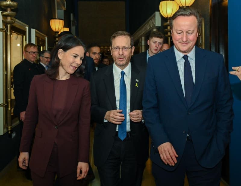 Israeli's President Isaac Herzog (C) welcomes Annalena Baerbock (L), Germany's Foreign Minister, and David Cameron (R), UK's Secretary of State, ahead of a meeting at a hotel in Jerusalem Maayan Toaf/GPO/dpa