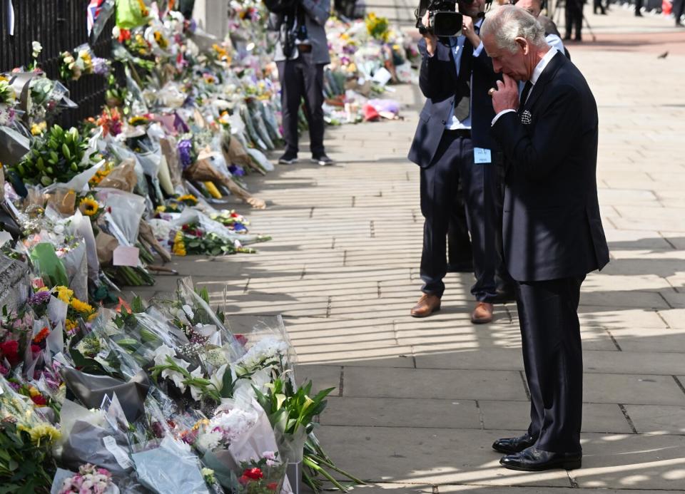 King Charles III views floral tributes to the late Queen Elizabeth II outside Buckingham Palace