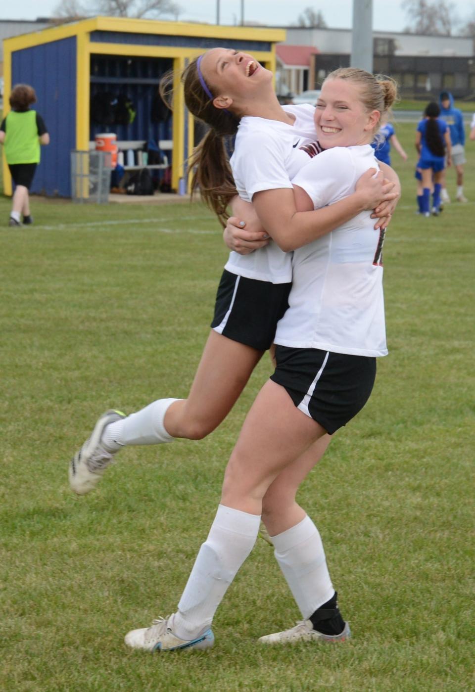 Molly Walline (left) gets a hug from Milan teammate Marissa Beck after scoring the final goal of an 8-0 victory over Jefferson-Erie Mason Wednesday.