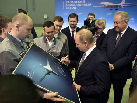 Russian President Vladimir Putin signs a picture of a TU-160M nuclear bomber during a visit to the Gorbunov Aviation factory in Kazan, Russia January 25, 2018. Sputnik/Alexei Nikolsky/Kremlin via REUTERS