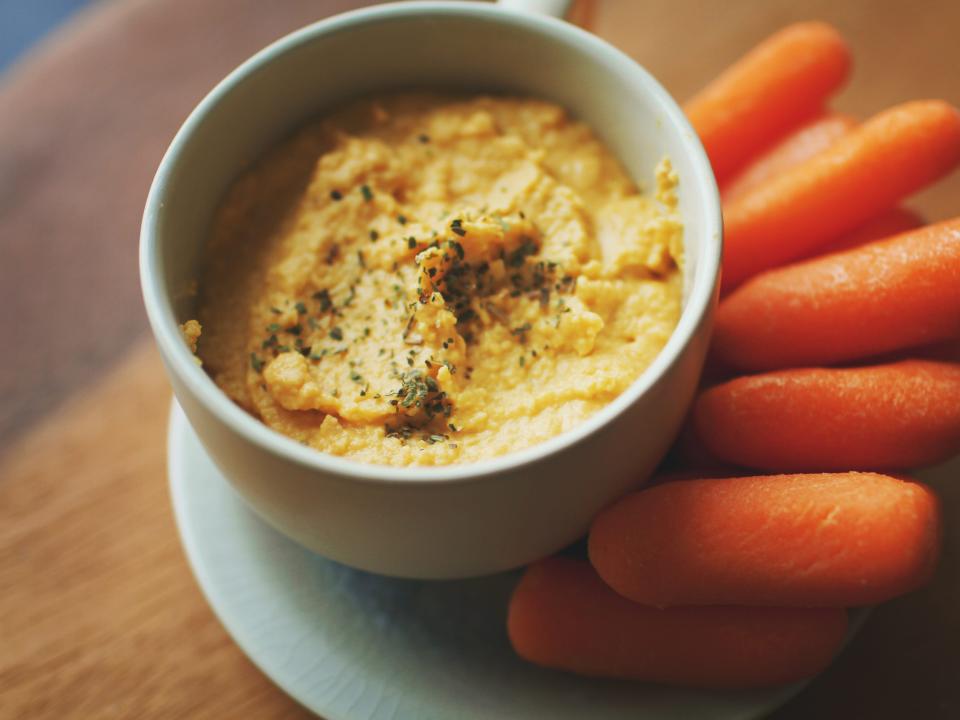 Bowl of hummus and a side of baby carrots.