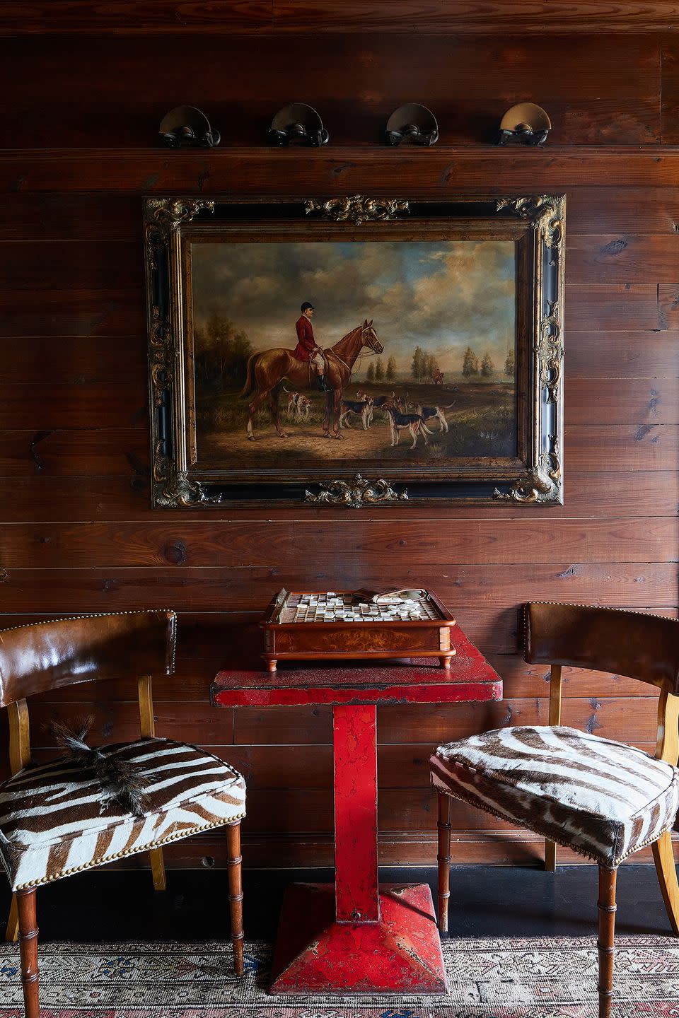 room with zebra patterned chairs and red table