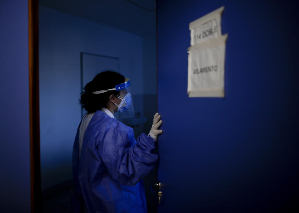 La doctora Verónica Verdino entra en una sala para comprobar el estado de pacientes de COVID-19 en el Hospital Llavallol Dr. Norberto Raúl Piacentini en Lomas de Zamora, Argentina, el sábado 8 de mayo de 2021. Saturday, May 8, 2021. Hace poco más de un año, antes de que la pandemia golpeara a Argentina, la médica de 31 años no imaginaba que tendría que entubar a tantos pacientes. (AP Foto/Natacha Pisarenko)