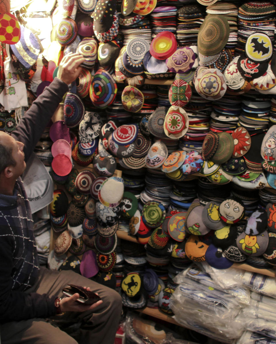 FILE - In this Tuesday, Feb. 9, 2010 file photo, an Israeli man sits in his stall where he sells skull caps in downtown Jerusalem. A lawyer representing DC Comics and Marvel says the comics giants are suing a Jerusalem vendor for selling Jewish skullcaps, or kippas, adorned with unauthorized images of crime-fighting superheroes Batman and Spiderman. Lawyer Chagay Netzer said the "Kippa Man" store was violating the intellectual property rights of both companies. DC Comics and Marvel are each demanding 25,500 U.S. dollars in damages and expect the store to stop selling the kippas.(AP Photo/Tara Todras-Whitehill, File)