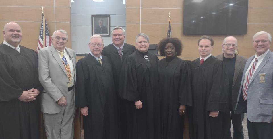 Senior Resident Superior Court Judge Mark E. Klass (center) stands with other District 22B judges, county commissioners Fred McClure and Steve Shell and artist Chip Holton (second from left) during a dedication of a courtroom.