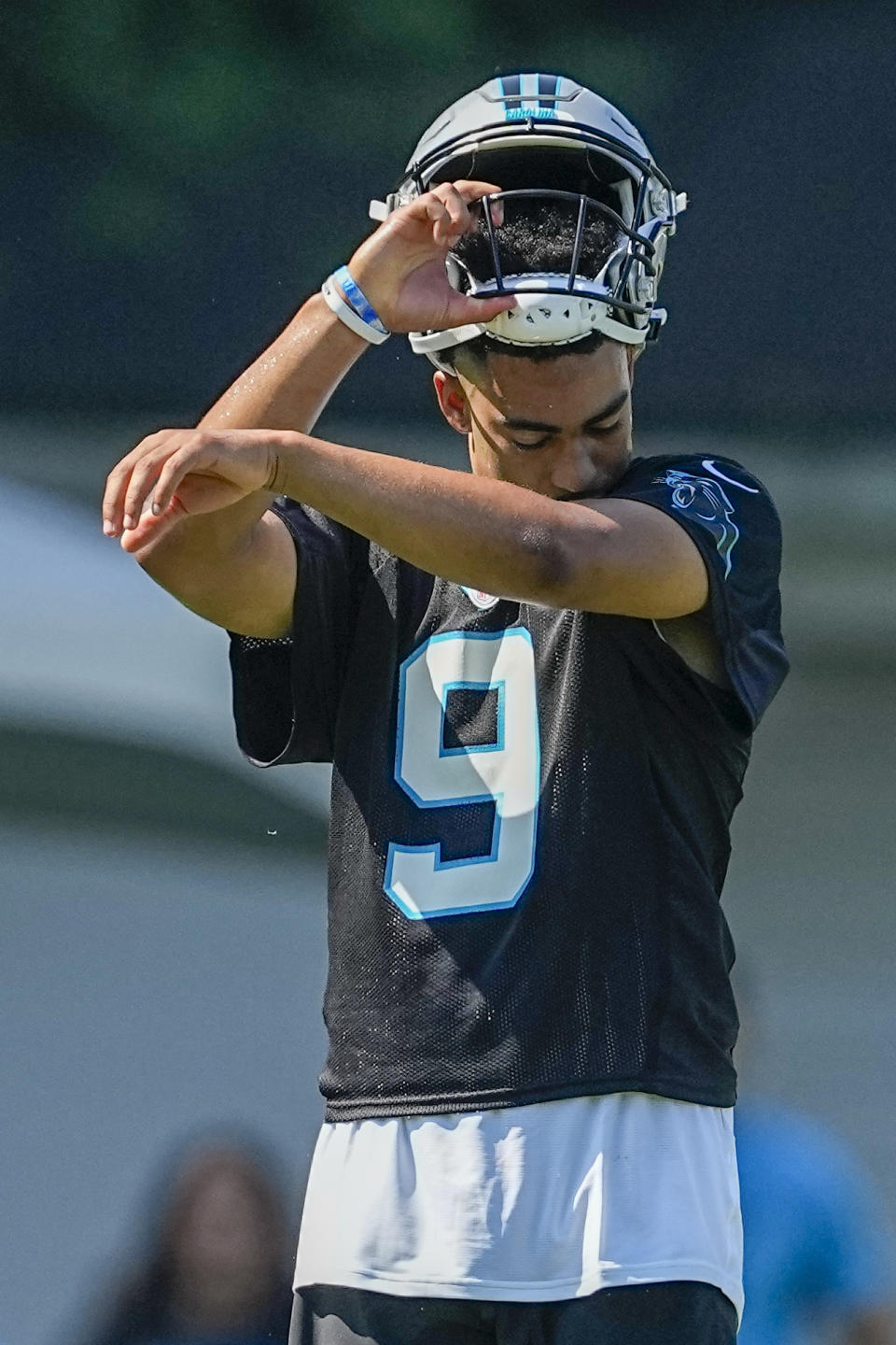 Carolina Panthers quarterback Bryce Young wipes his face during drills at the NFL football team's training camp on Wednesday, July 26, 2023, in Spartanburg, S.C. (AP Photo/Chris Carlson)