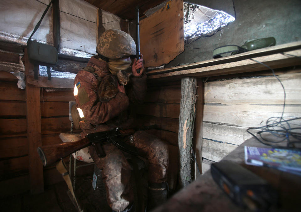 A member of the Ukrainian government military forces looks through a telescope from his position on the front line with Russia backed separatists, near Novognativka village in Ukraine's eastern Donetsk region, February 21, 2022. / Credit: ANATOLII STEPANOV/AFP/Getty