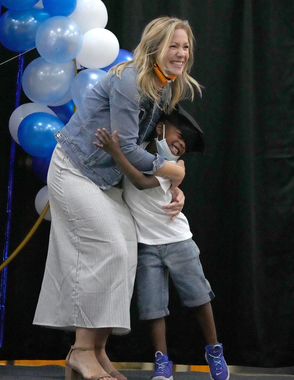 Graduate De'Moni Coleman hugs his teacher, Megan Kaupla, during a K5 promotion ceremony at the Milwaukee Academy of Science.