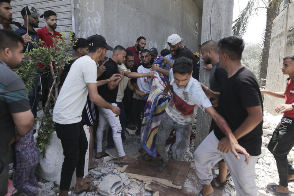 Palestinians evacuate dead and wounded in the Israeli bombardment of the Gaza Strip in Deir al Balah on Saturday, June 8, 2024. (AP Photo/Jehad Alshrafi)