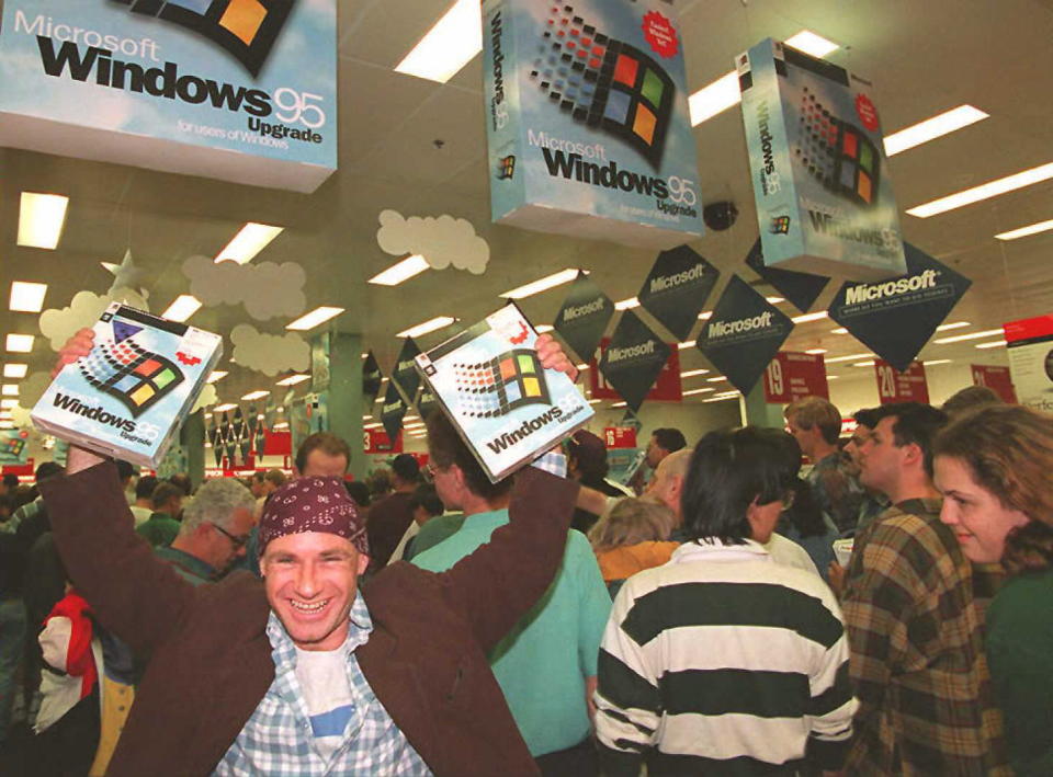 A giddy Australian customer holds aloft his two copies of Windows 95 in Syndey after the launch at midnight on August 24. (Getty)