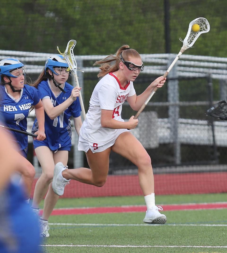 Somers' Teagan Ryan (14) breaks away from Hen Hud's Lexi Robinson (7) and Lena Pfeiffer (17) as she drives to the goal during girls lacrosse action at Somers High School May 11, 2023. Somers won the game 12-7.