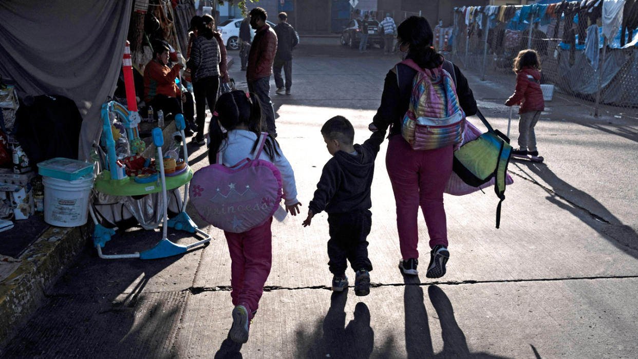 A family arrives at an improvised camp of asylum seekers and refugees at the El Chaparral border crossing in Tijuana, Baja California state, Mexico, on Dec. 6.