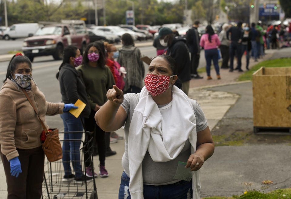 Volunteer Elizabeth Castro asks people in line to stand 6ft apart along Greenwich Street in Reading, PA on April 25, 2020. (Photo: Ben Hasty/MediaNews Group/Reading Eagle via Getty Images)