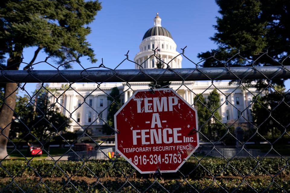 A temporary six-foot high chain link fence surrounds the state Capitol because of concerns over the potential for civil unrest, in Sacramento, Calif., Jan. 14, 2021. Along with the fence, Gov. Gavin Newsom has mobilized he National Guard and other precautions over concerns that protests around next week's inauguration of President-elect Joe Biden could turn violent and destructive. 