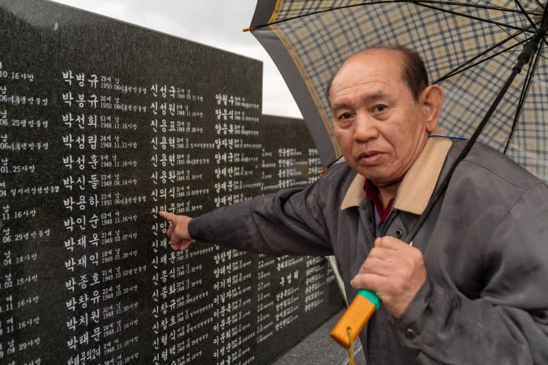 Shin Yong-soon, 79, points to the name of a family member who died during the Jeju Massacre on Wednesday at the Jeju 4.3 Peace Park in Jeju City, South Korea. Photo by Darryl Coote/UPI