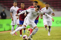 El mexicano Rogelio Funes Mori, al frente, y el costarricense Ronald Matarrita pelean por el balón durante un partido por la segunda fecha del octagonal final de la CONCACAF al Mundial de Qatar 2022, en San José, Costa Rica, el domingo 5 de septiembre de 2021. (AP Foto/Arnulfo Franco)