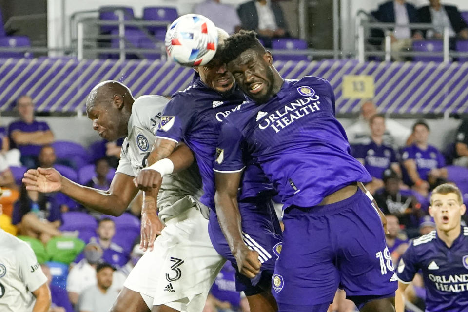 Orlando City's Junior Urso, center, and Daryl Dike (18) try to he'd the ball toward the goal as CF Montreal's Kamal Miller (3) defends during the second half of an MLS soccer match, Wednesday, Oct. 20, 2021, in Orlando, Fla. (AP Photo/John Raoux)