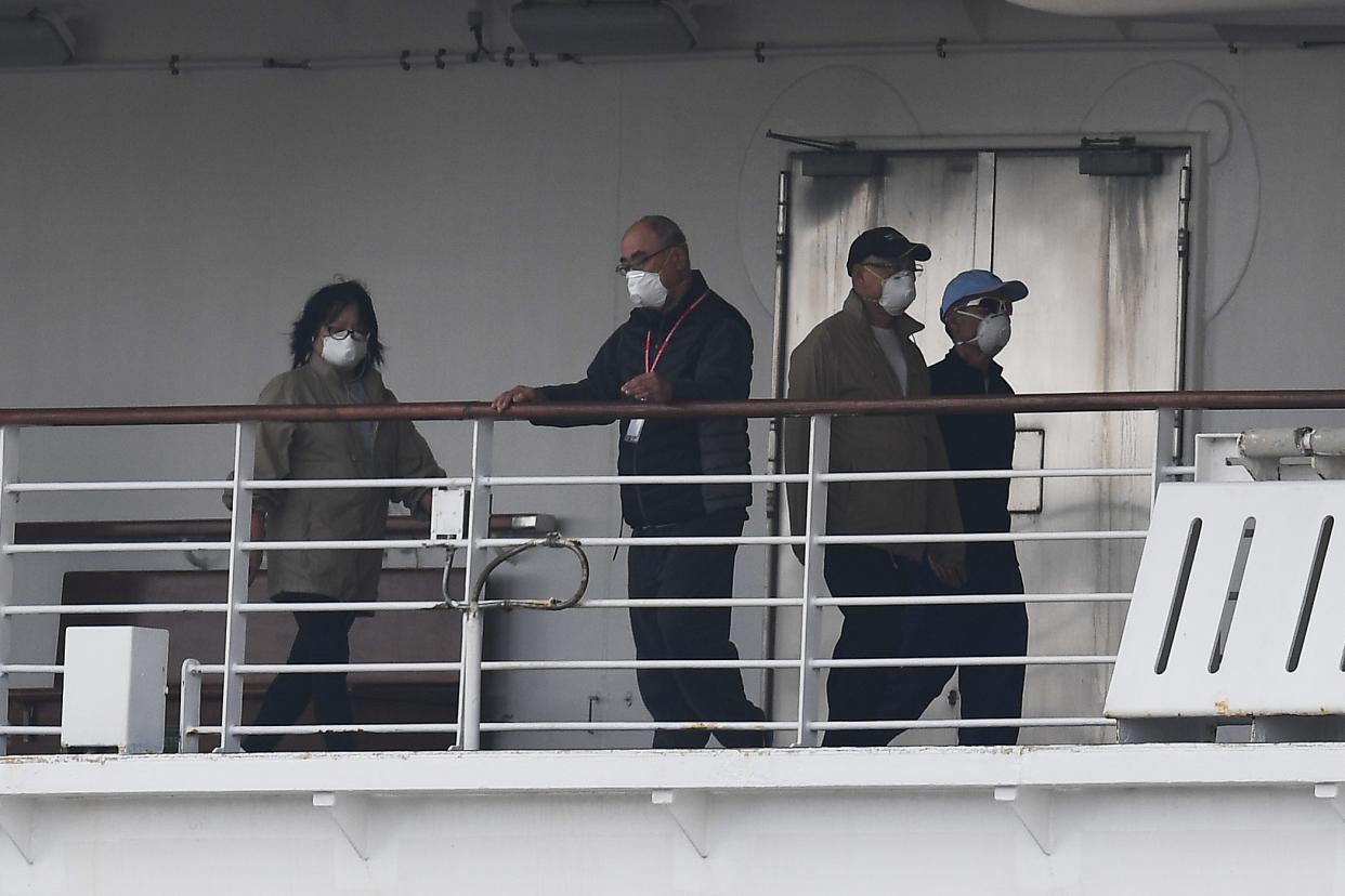 Passengers are seen on the deck of the Diamond Princess cruise ship, with around 3,600 people quarantined onboard due to fears of the new coronavirus, at the Daikoku Pier Cruise Terminal in Yokohama port on February 14, 2020. - The death toll from China's coronavirus epidemic neared 1,500 on February 14 as the United States complained of a lack of transparency from Beijing over its handling of a crisis that has fuelled global panic. (Photo by CHARLY TRIBALLEAU / AFP) (Photo by CHARLY TRIBALLEAU/AFP via Getty Images)