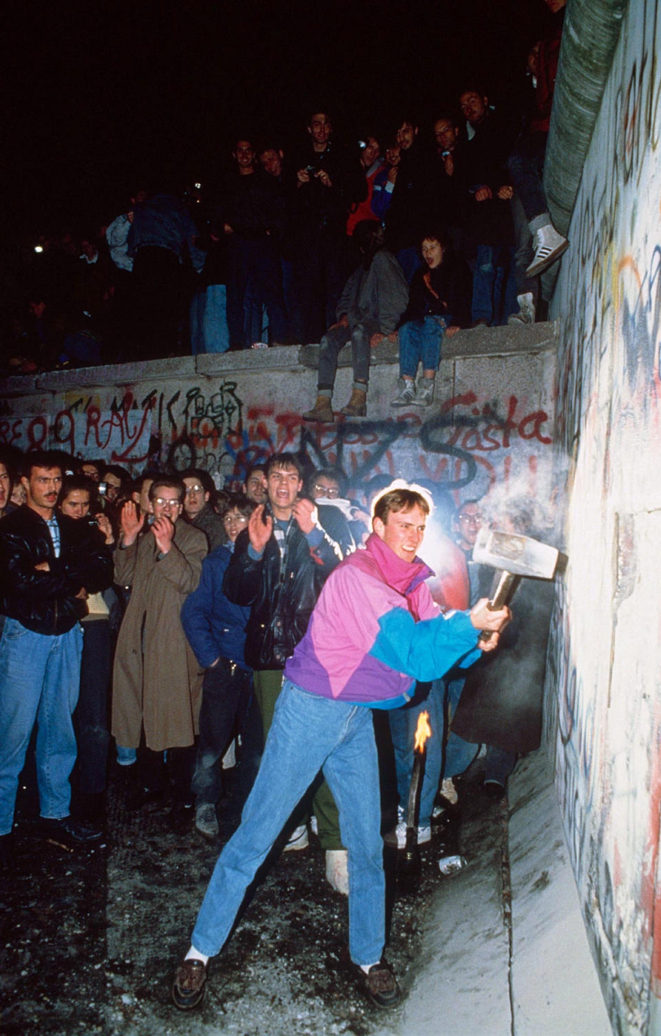 12/11/1989- Joyous Berliners break cheer as a young man hammers at the wall. Picture- Corbis Images