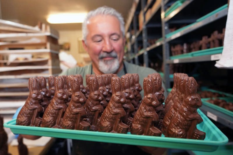 Owner Andy Karandzieff carries a tray of chocolate bunnies to the front of the store for Easter sales at Crown Candy Kitchens in St. Louis on Wednesday, March 27, 2024. Photo by Bill Greenblatt/UPI