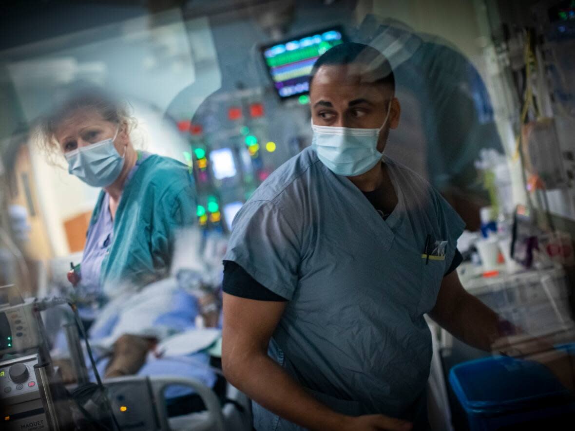 Nurse Dave Riar checks on a patient in ICU at the Royal Columbia Hospital in New Westminster, B.C. in March 2022. CBC's look inside the hospital's COVID ICU earned a Webster nomination in the category of Best Feature/Enterprise Reporting – TV/Video. (Ben Nelms/CBC - image credit)