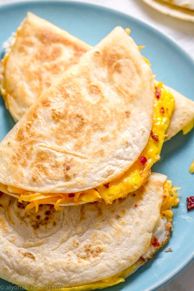 <p>Eggs, cheese and bacon pieces are folded inside a soft tortilla and then toasted to melty goodness! These small-sized tortillas make the perfect-sized breakfast quesadillas and can make a creative egg appearance!</p><p><strong>Get the recipe: <a href="https://www.alyonascooking.com/breakfast-quesadillas/" rel="nofollow noopener" target="_blank" data-ylk="slk:Ham, Cheese and Bacon Breakfast Quesadillas;elm:context_link;itc:0;sec:content-canvas" class="link "><em>Ham, Cheese and Bacon Breakfast Quesadillas</em></a></strong></p><p><strong>Related: <a href="https://parade.com/849172/andreagleeson/15-chicken-quesadilla-recipes-you-should-make-for-dinner-soon/" rel="nofollow noopener" target="_blank" data-ylk="slk:15 Chicken Quesadilla Recipes You Should Make For Dinner Soon;elm:context_link;itc:0;sec:content-canvas" class="link ">15 Chicken Quesadilla Recipes You Should Make For Dinner Soon</a></strong></p><p>Alyona's Cooking</p>