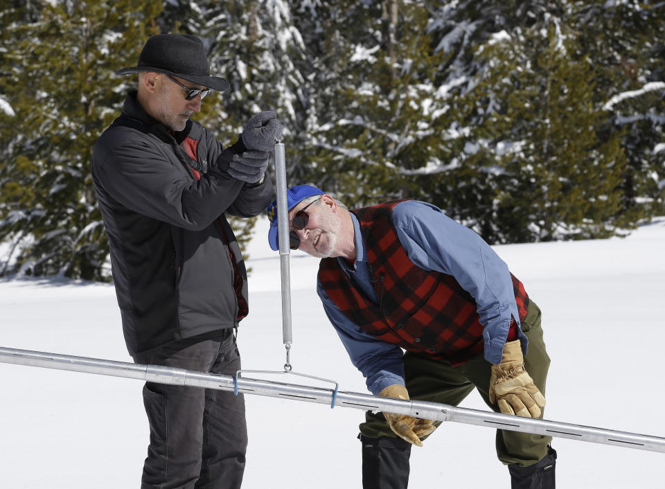 Frank Gehrke, right, chief of the California Cooperative Snow Surveys Program for the Department of Water Resources, checks the weight of the snowpack on a scale held by Armando Quintero, chairman of the California Water Commission, during the third manual snow survey of the season at Phillips Station, Wednesday, March 1,2017, near Echo Summit, Calif. The survey showed the snowpack at 179 percent of normal for this location at this time of year.The state's electronic snow monitors say the Sierra Nevada snowpack is at 185 percent of normal. (AP Photo/Rich Pedroncelli)