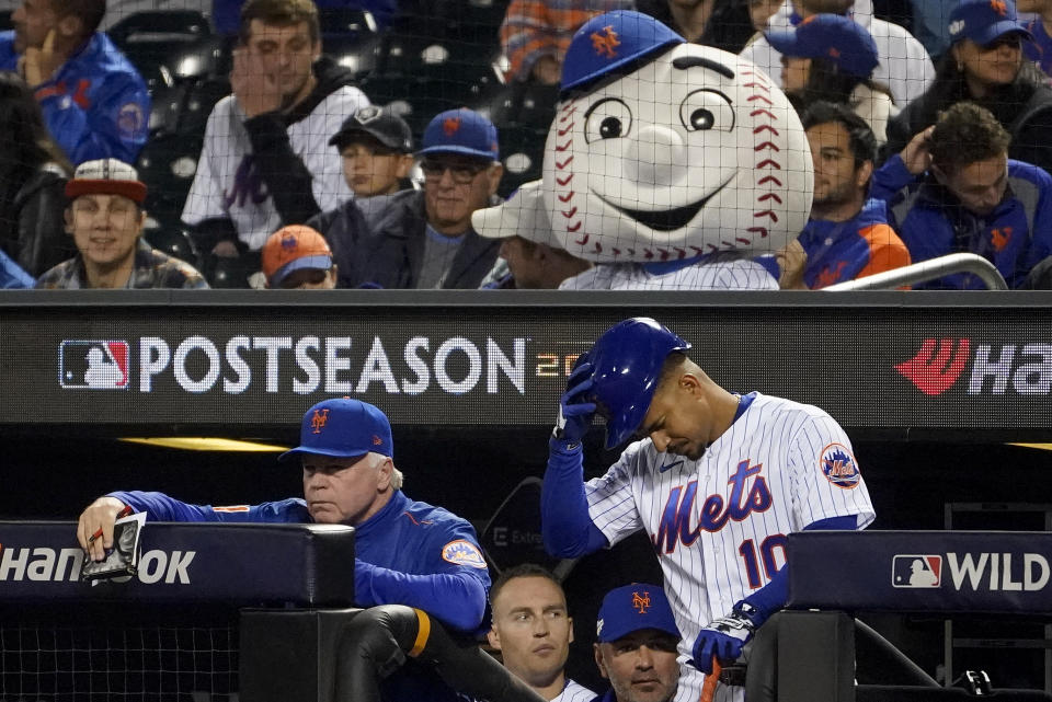 El mánager de los Mets de Nueva York, Buck Showalter, a la izquierda, observa el juego desde el banquillo mientras Eduardo Escobar (10) se prepara para batear contra los Padres de San Diego durante la octava entrada del Juego 3 de una serie de playoffs de béisbol comodín de la Liga Nacional, el domingo 1 de octubre de 2019. 9, 2022, en Nueva York.  (Foto AP/John Minchillo)