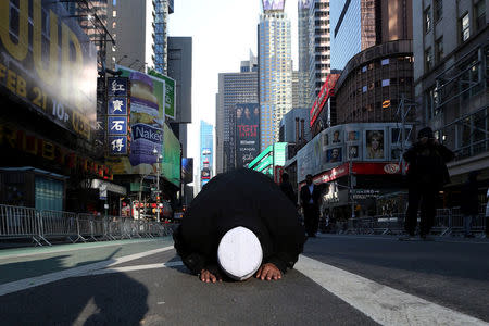 A Muslim man kneels on Broadway Ave. as he takes part in afternoon prayers during an "I am Muslim Too" rally in Times Square, Manhattan, New York, U.S. February 19, 2017. REUTERS/Carlo Allegri/Files