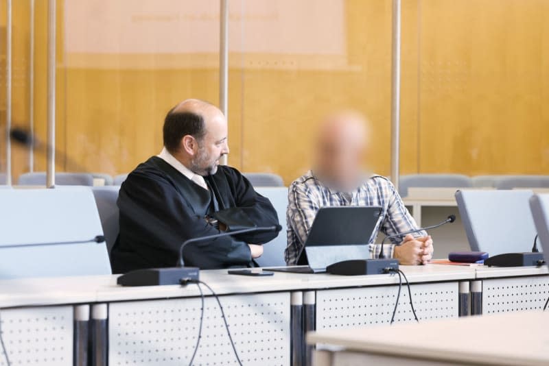 Lawyer Marvin Schroth (l) talks to the accused German army officer in the espionage trial at the Higher Regional Court. The defendant was sentenced to three and a half years in prison for being a Russian spy. The Düsseldorf Higher Regional Court found the confessed man guilty of secret service agent activities. David Young/dpa